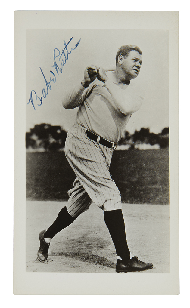 RUTH, BABE. Photograph postcard Signed, full-length portrait, showing him in uniform after swinging his bat.